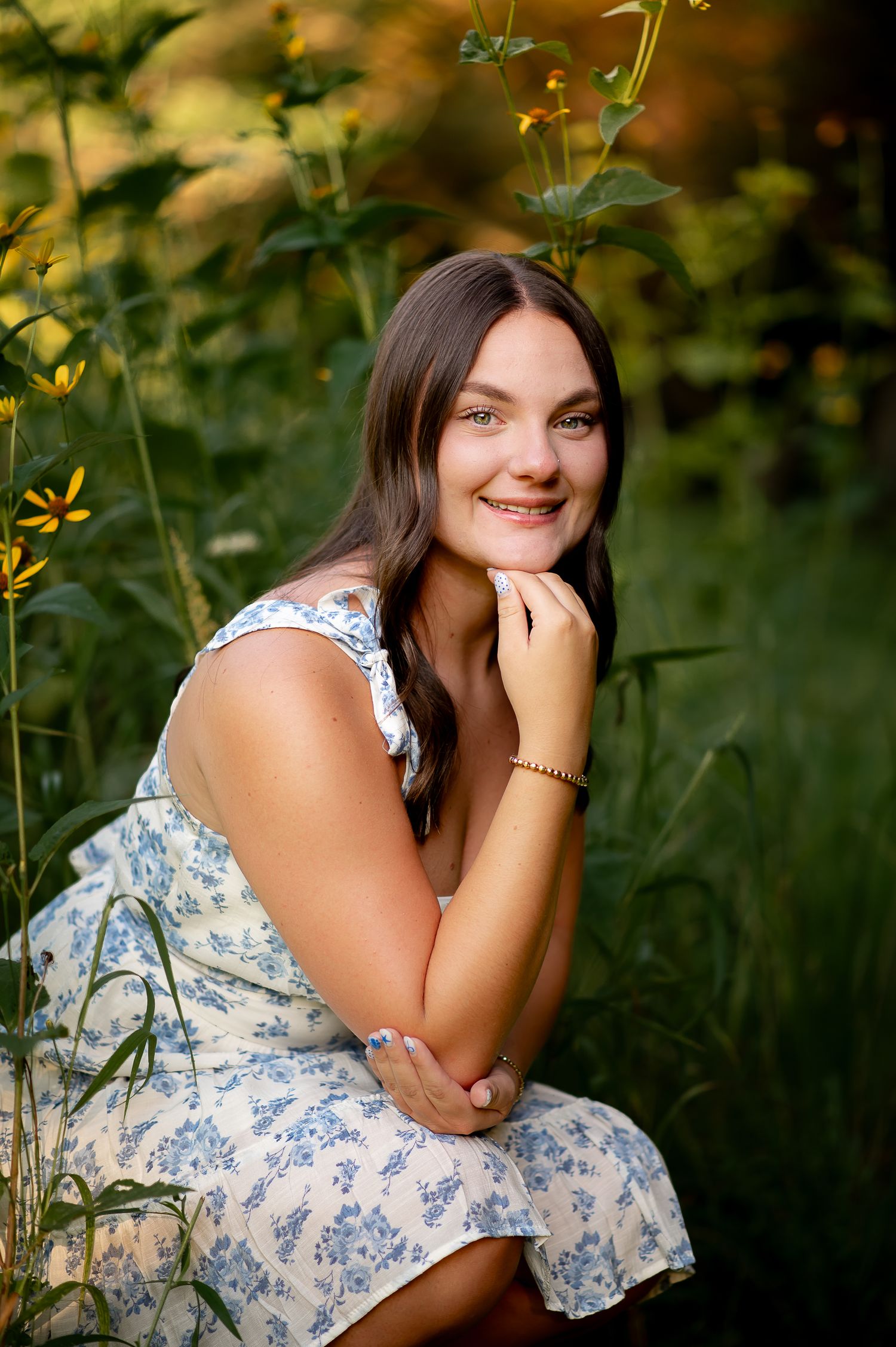 Natural summer portrait in floral dress among yellow wildflowers.