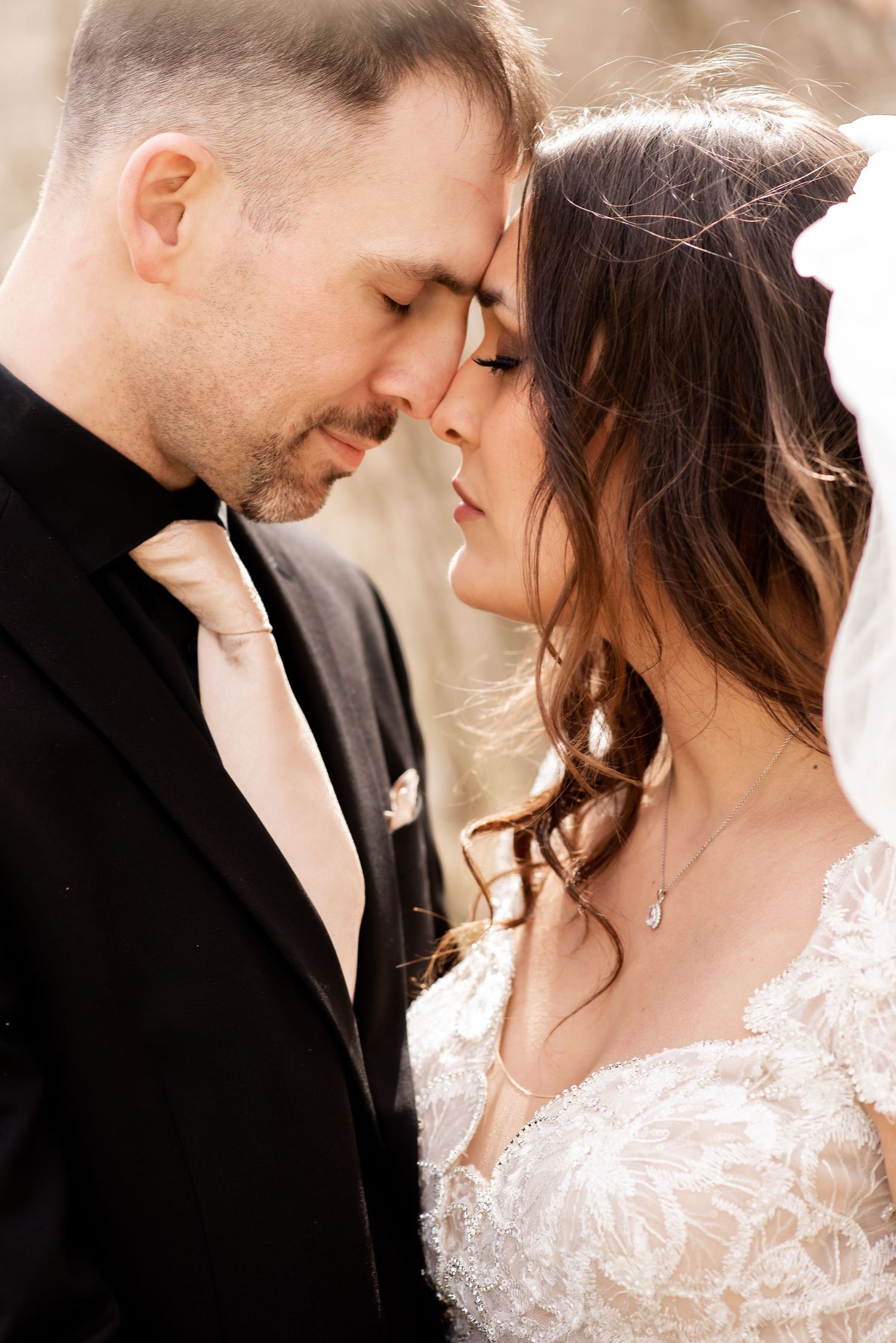 An intimate wedding portrait capturing a tender moment in warm natural light.