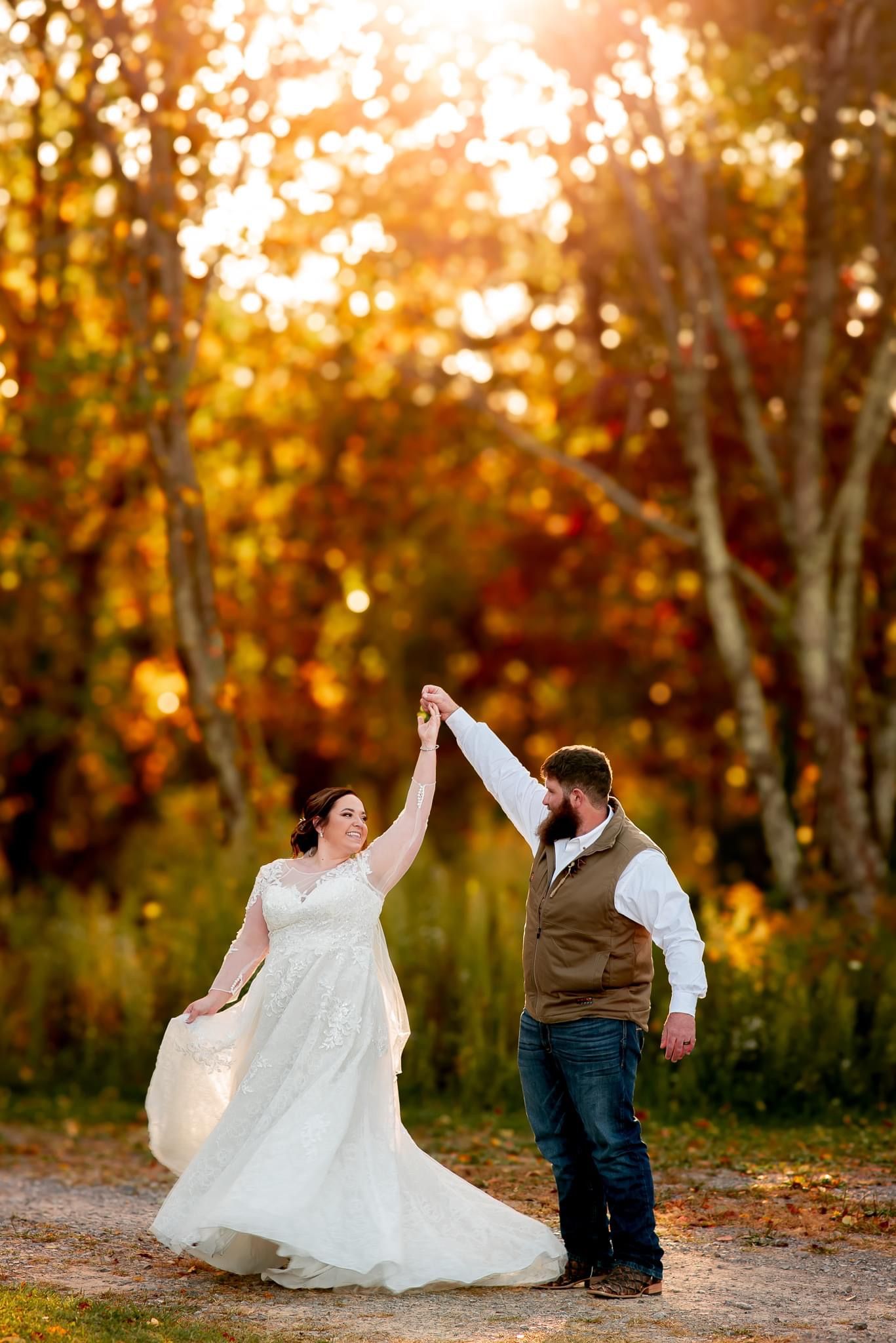 Dancing couple twirls in autumn sunlight surrounded by golden trees.