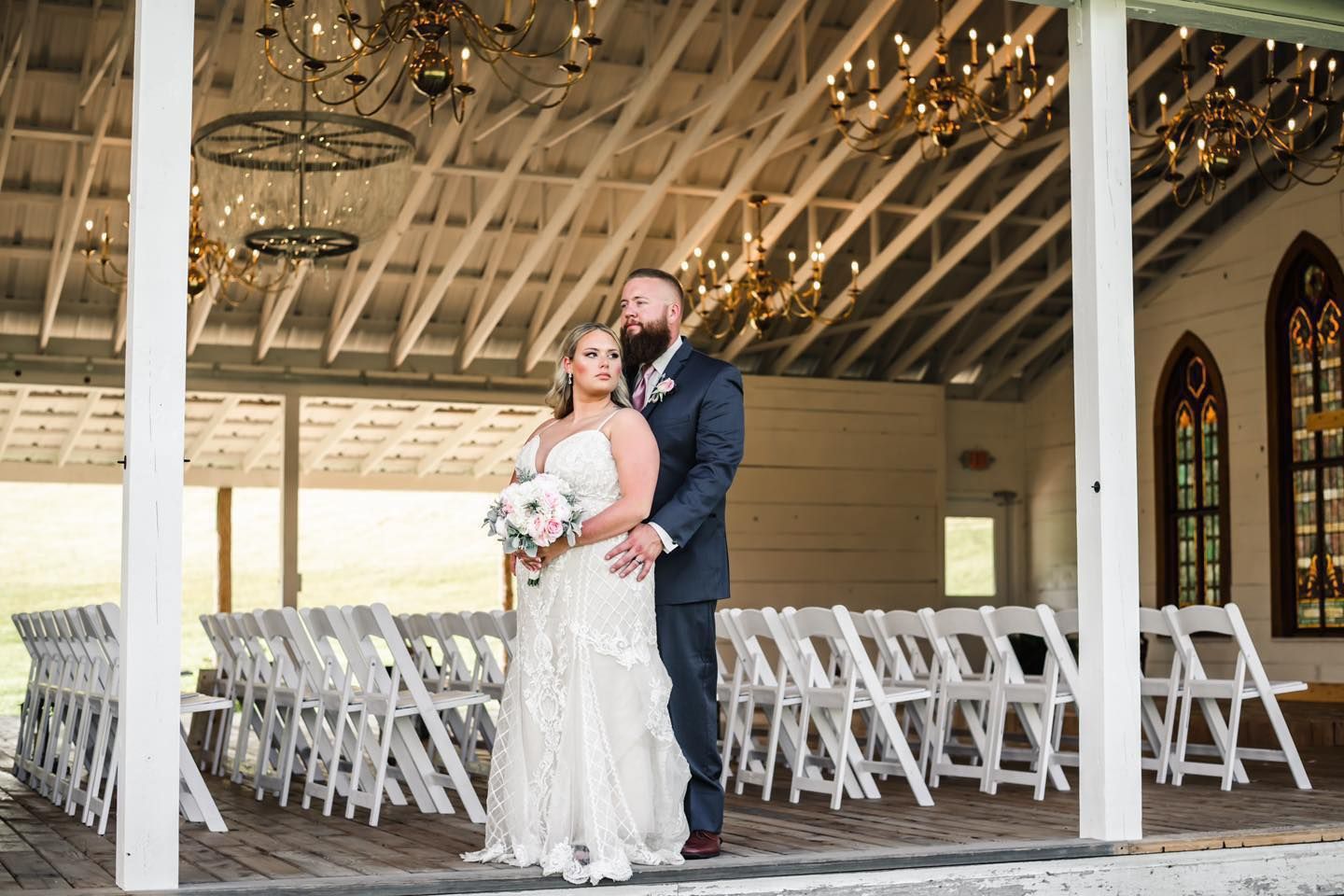An elegant indoor wedding venue with white chairs and twinkling lights creating a romantic atmosphere.