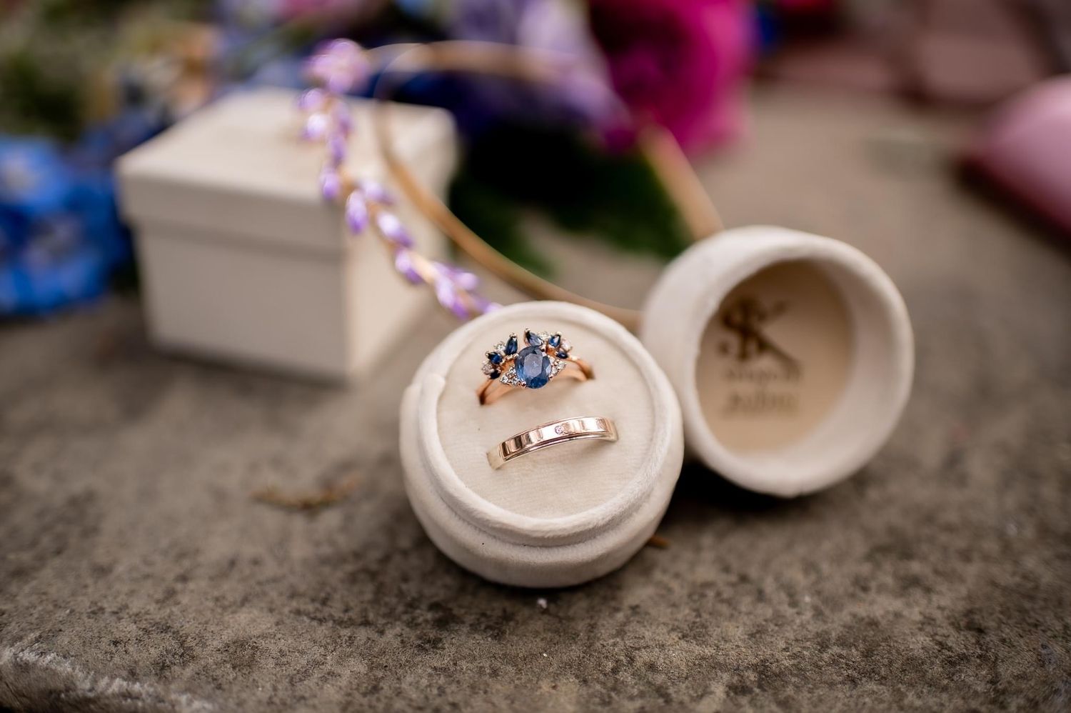 Wedding rings displayed in a white ceramic ring box with decorative details.