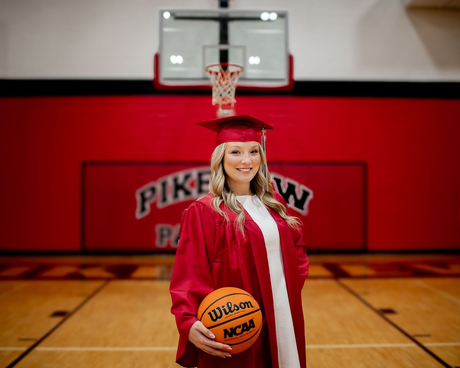 Wilson basketball with cap and tassel centerpiece displays graduation theme in school gymnasium.
