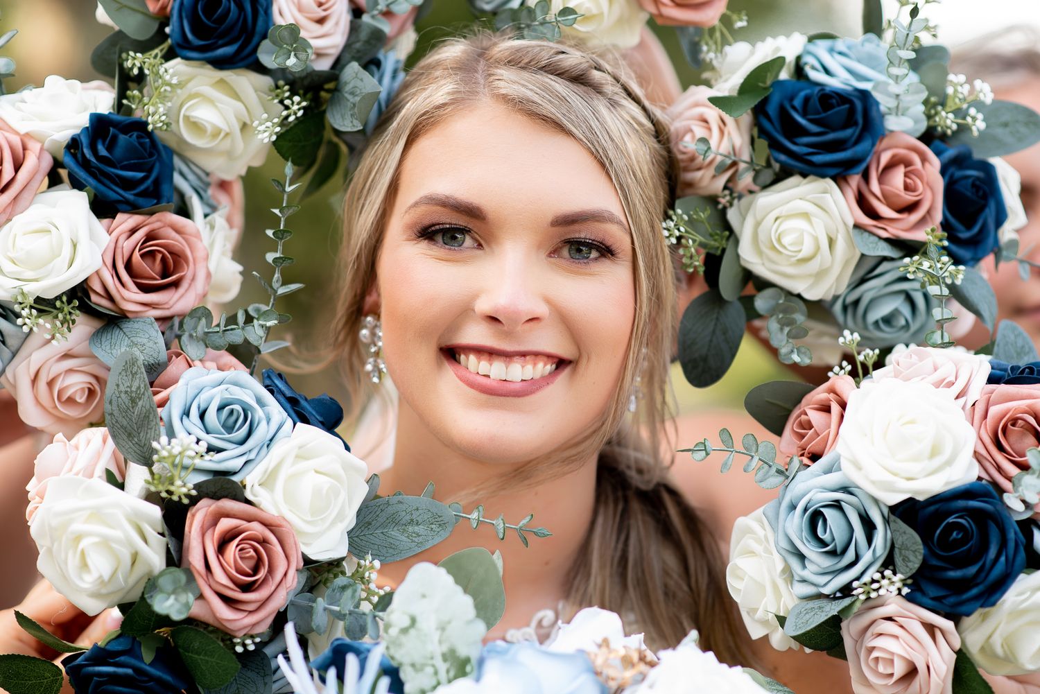 Navy blue and blush pink roses arranged in an elegant wedding bouquet.