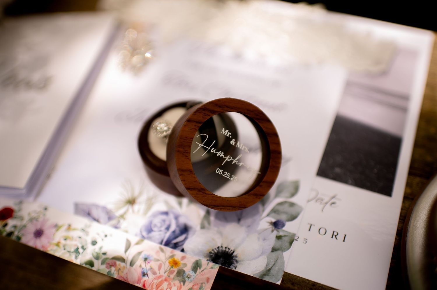 Wedding details photographed with soft focus including rings and printed materials.