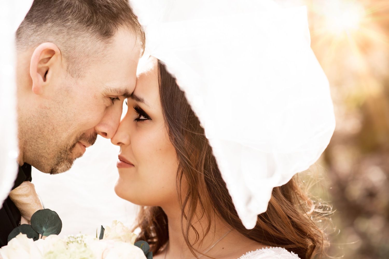 Romantic golden hour portrait with soft lighting and delicate veil details.