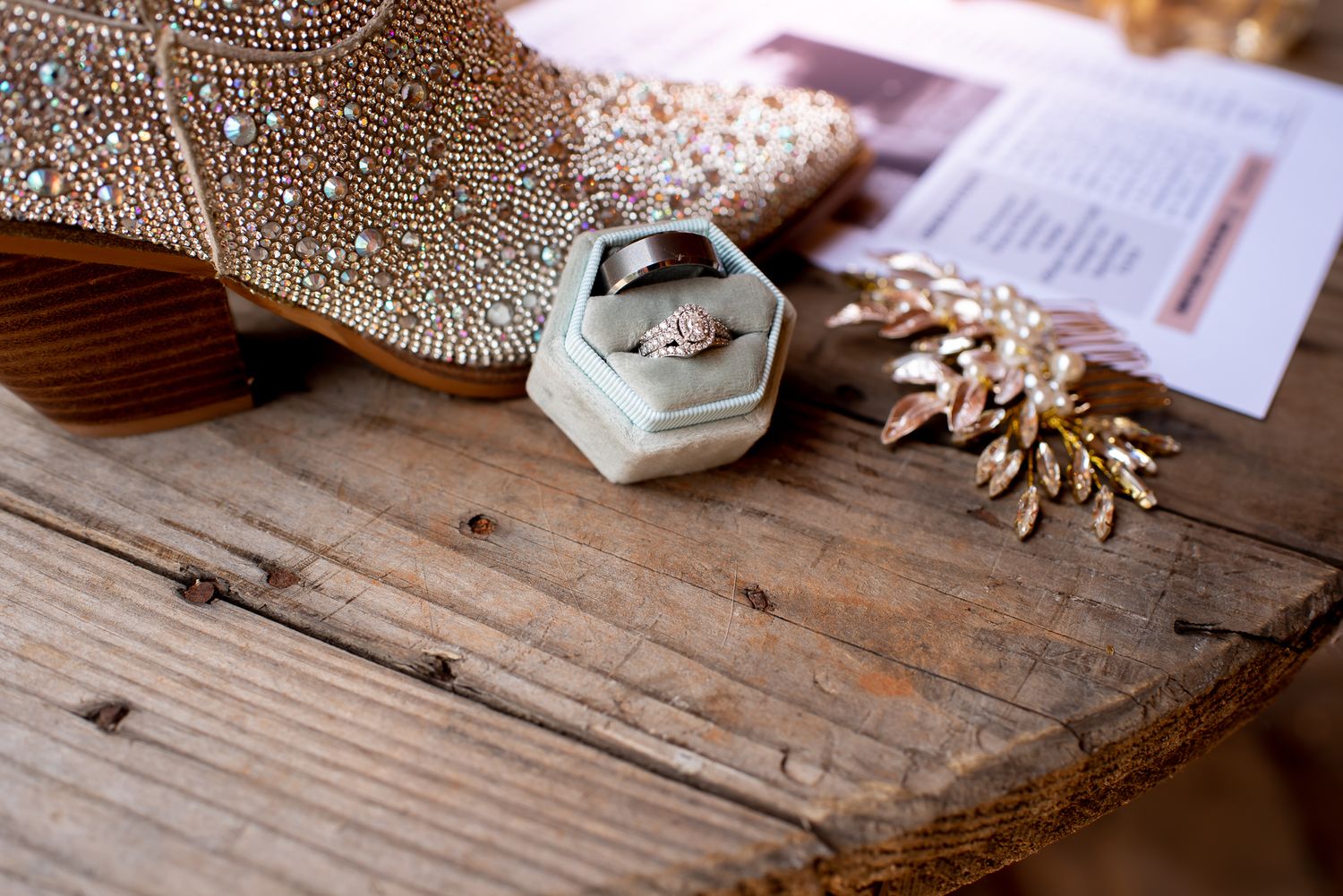 Delicate beaded details and wedding accessories displayed on rustic wooden surface.