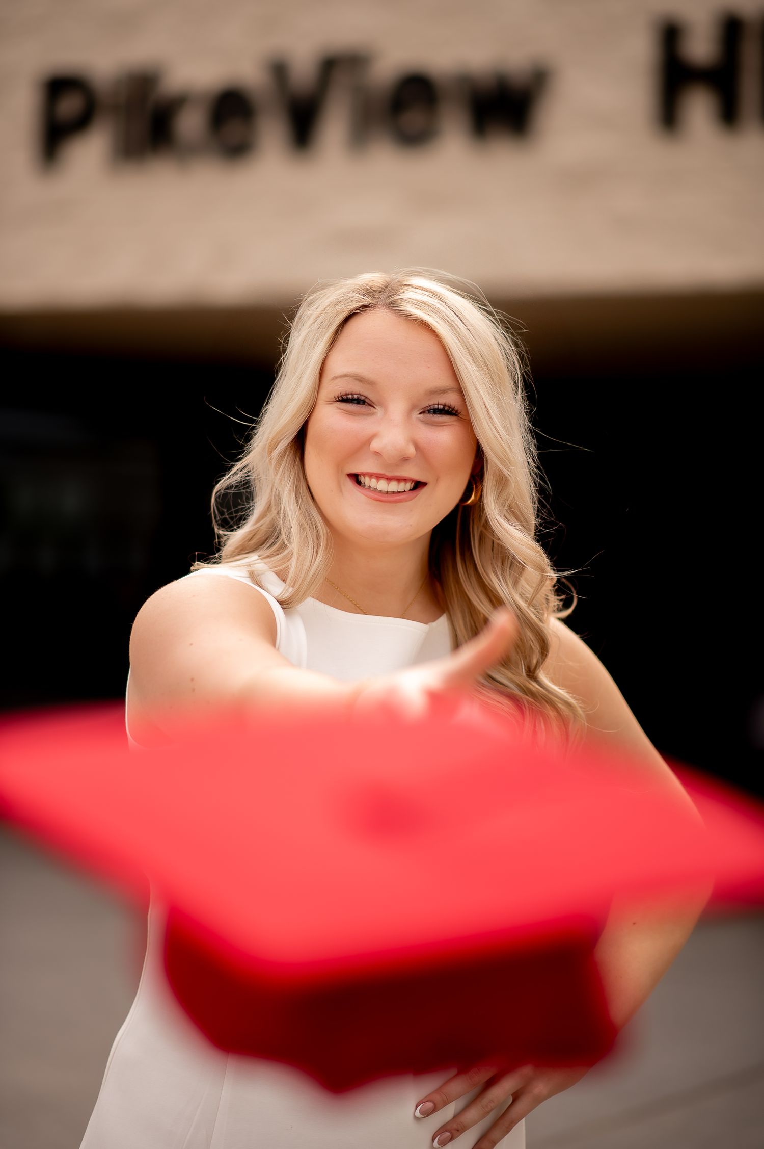 A creative graduation portrait with red cap in foreground at Pine View High School.