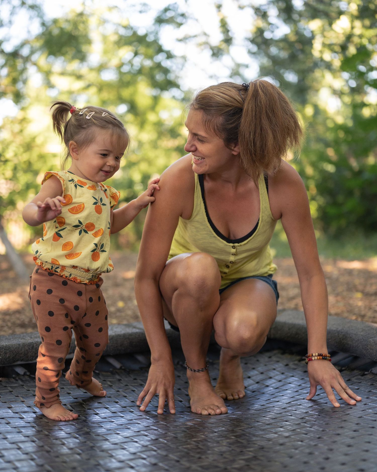 Frau und Kind auf einem Trampolin, beide lachen