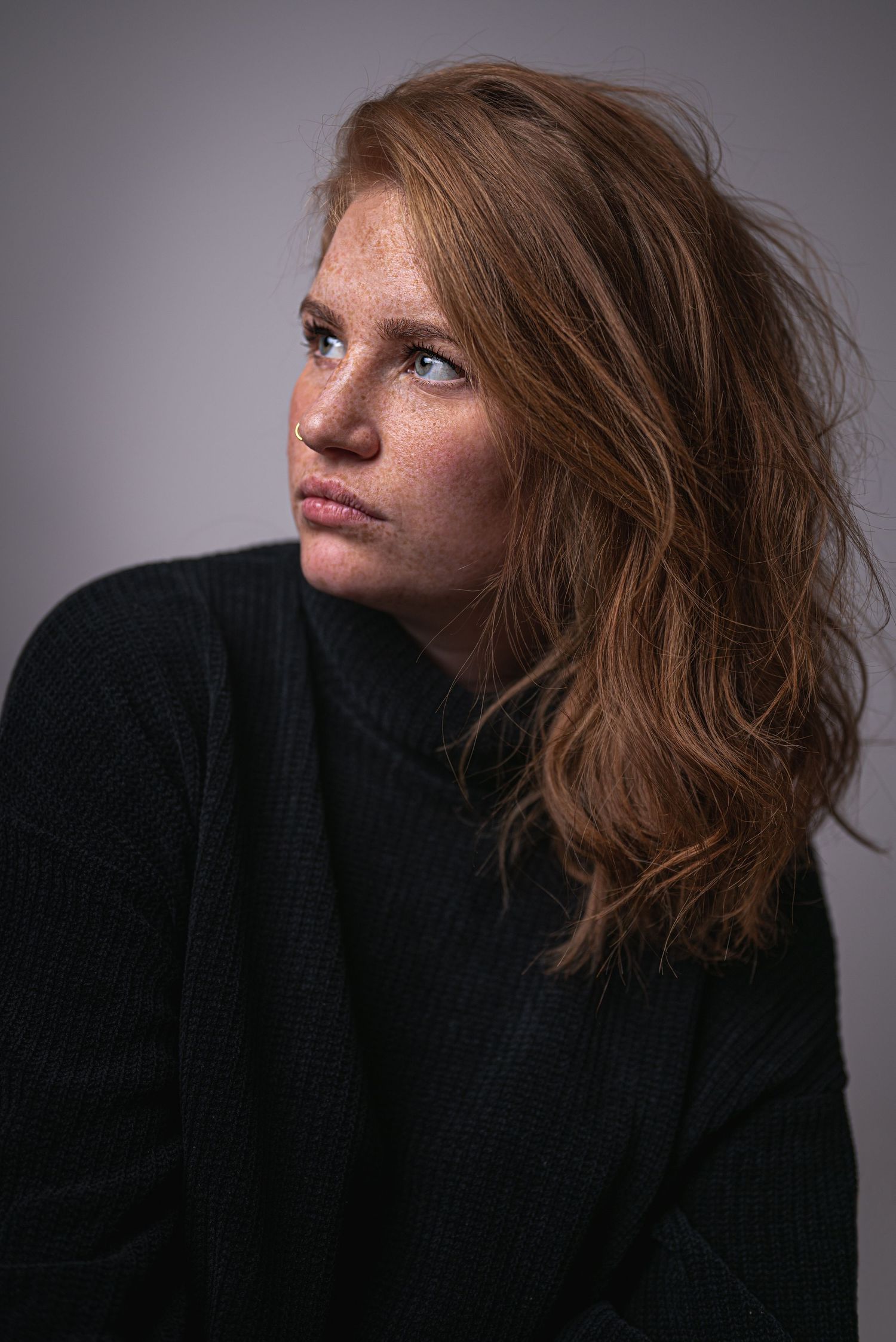Portrait einer Frau die auf die Seite schaut, rote Haare