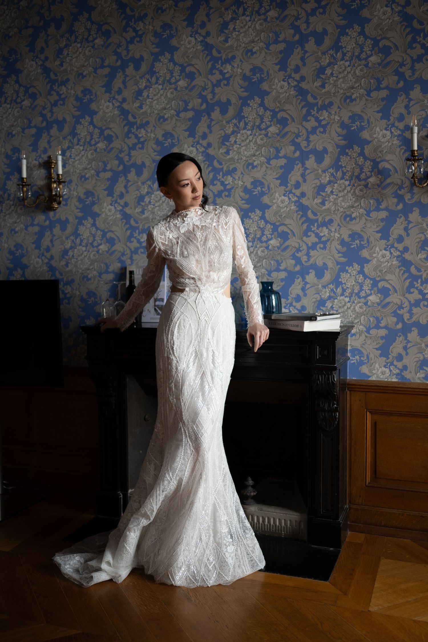 Fotografie einer Frau im Brautgleit, elegant am Kamin