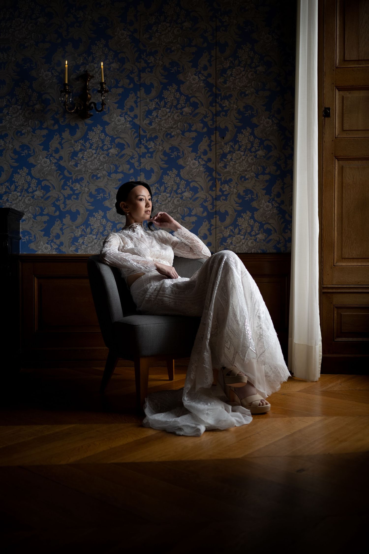 Fotografie einer Frau im Brautgleit, elegant sitzend auf einem Sessel