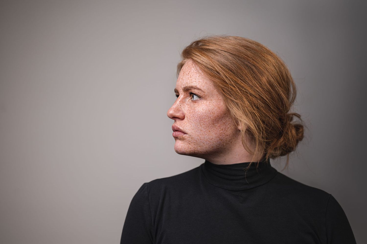 Portrait einer roothaarigen Frau, die zur Seite schuat
