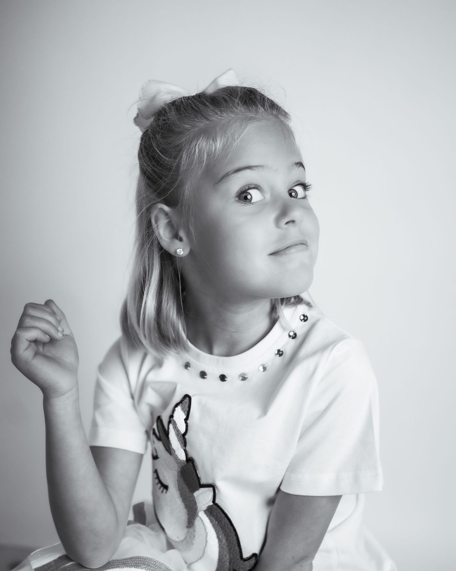 Confident young girl striking a sassy pose in black-and-white portrait – expressive child photography