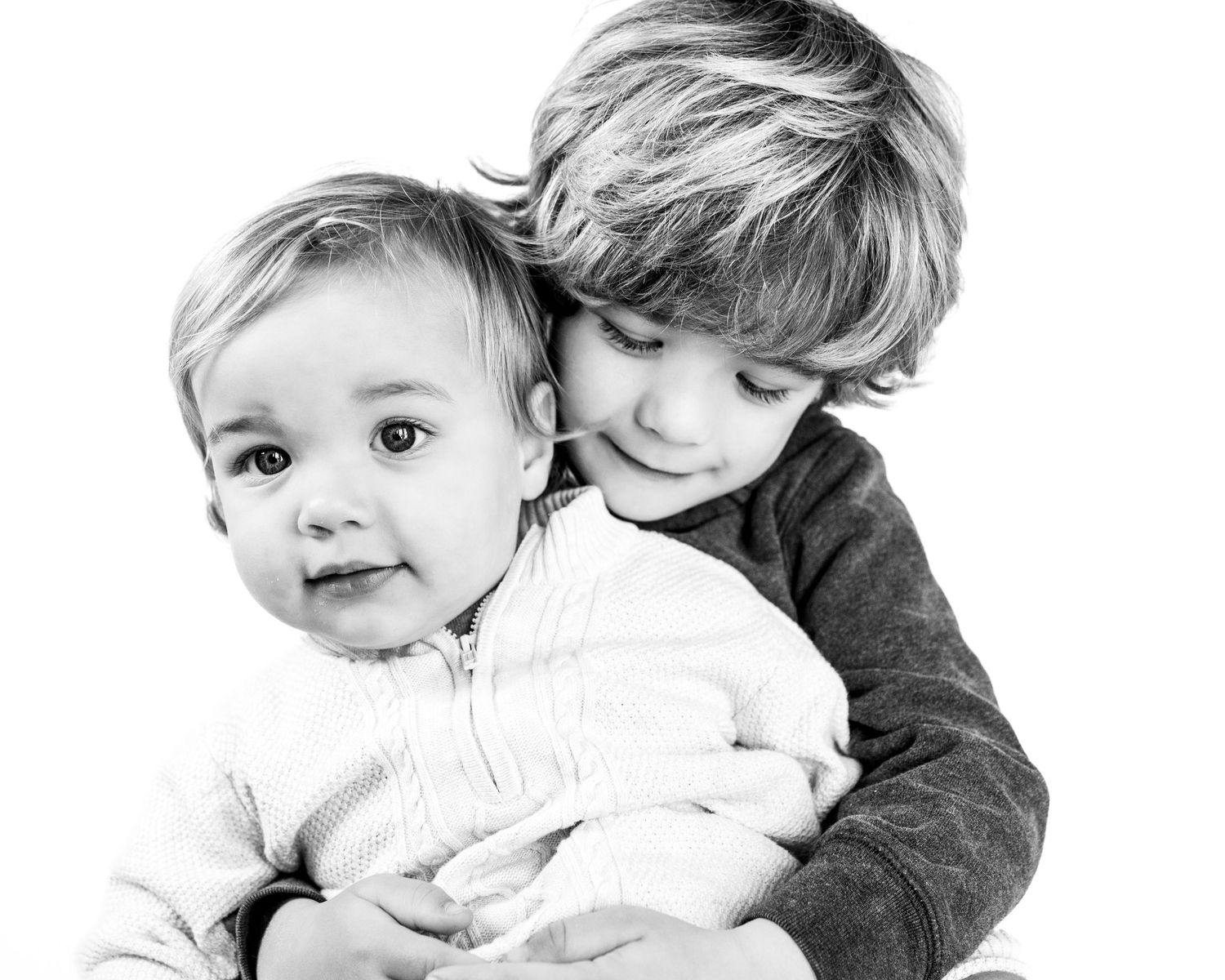 two brothers in a black and white image of a sweet embrace