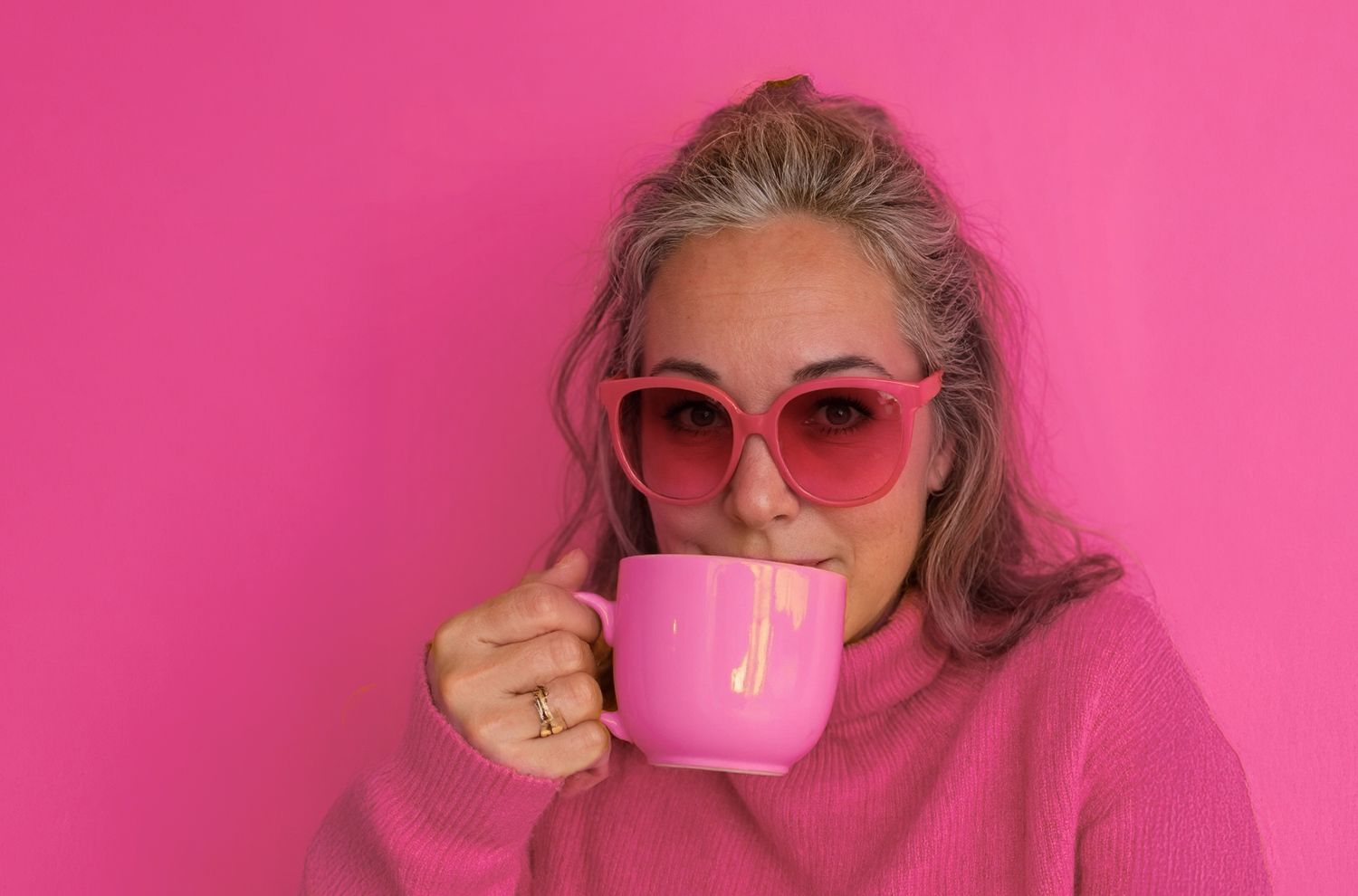Lauren Wilson in monochromatic pink outfit, drinking from a pink mug – playful and bold personal brand portrait