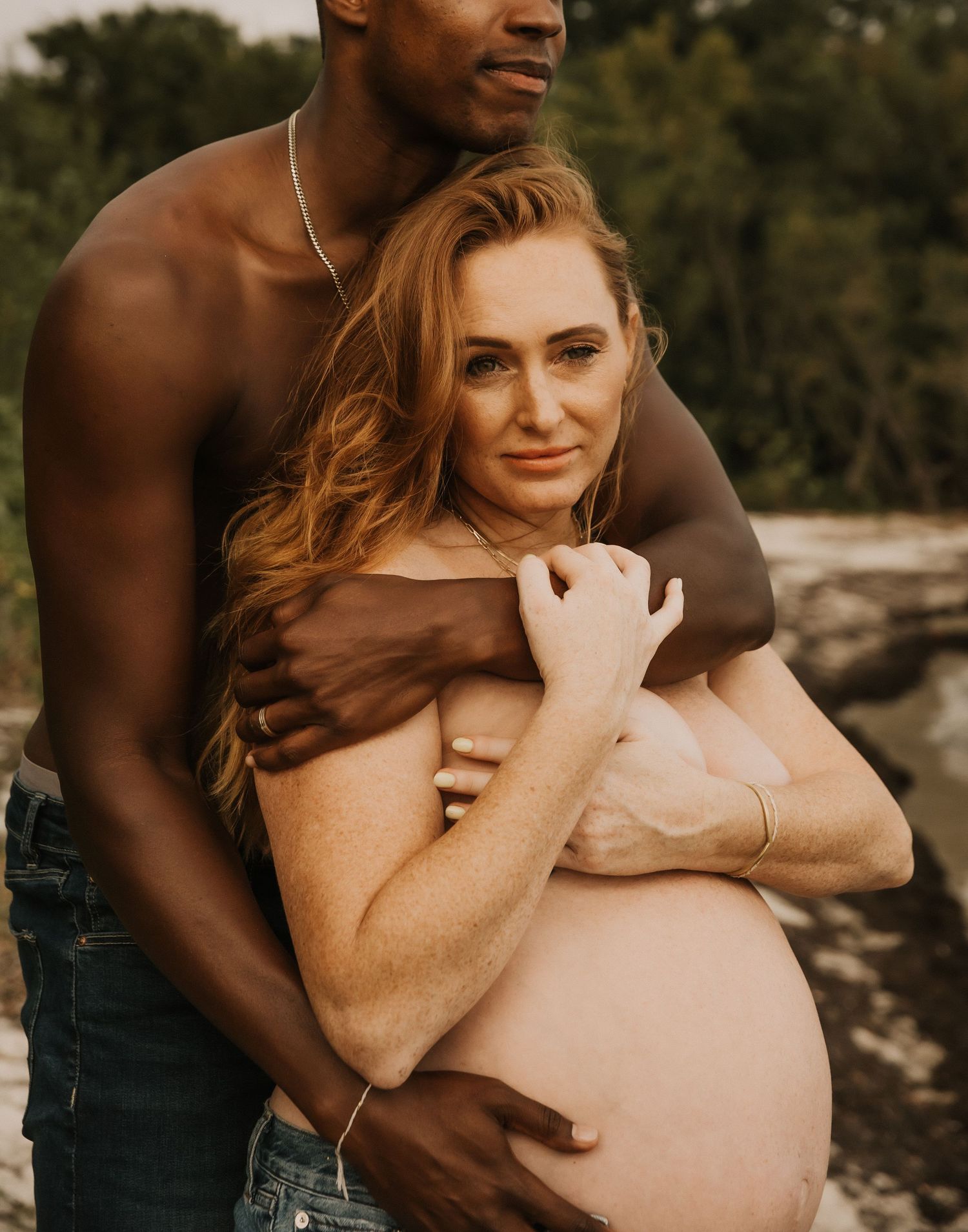 An intimate maternity portrait of an expectant couple outdoors.