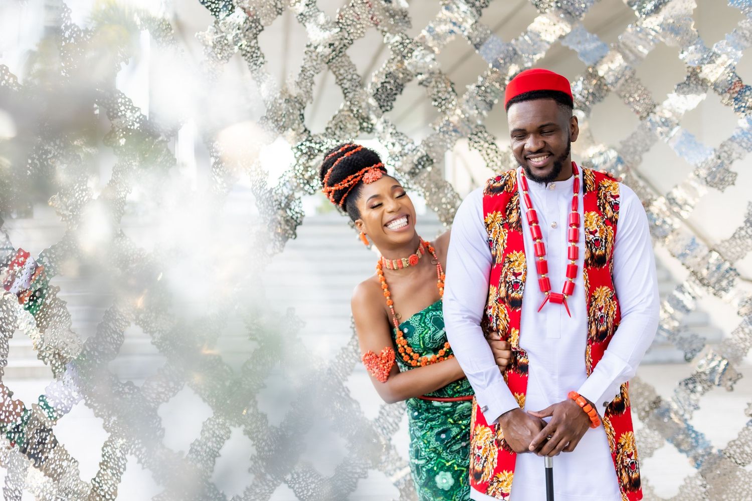 Traditional Nigerian wedding ceremony with colorful attire and cultural elements against a light background.