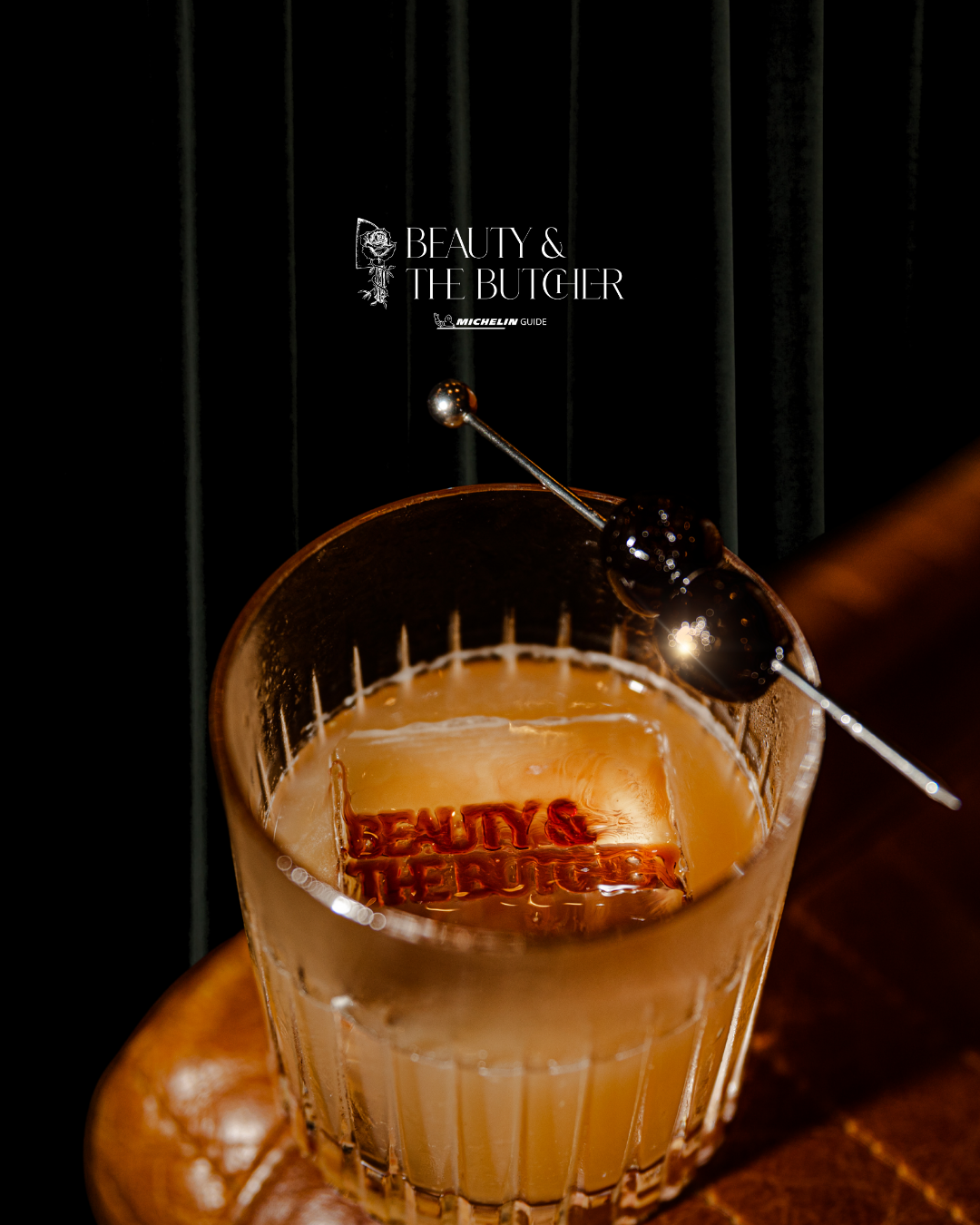 Craft cocktail in a coupe glass with decorative garnish and branding element.
