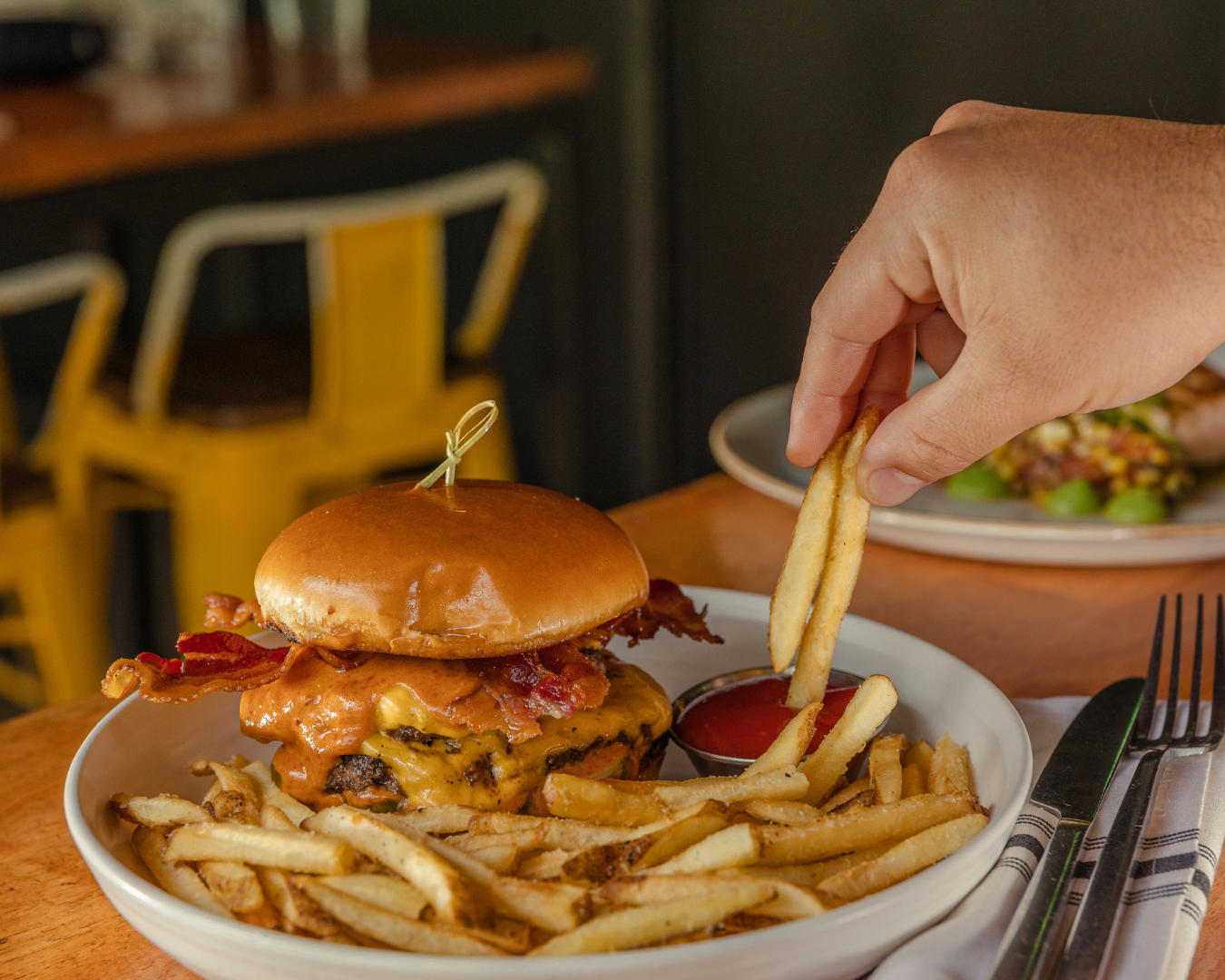 Classic cheeseburgers with golden french fries served on white plates.