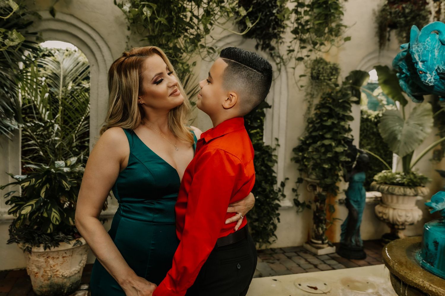 A romantic moment captured in an elegant indoor setting with decorative greenery.