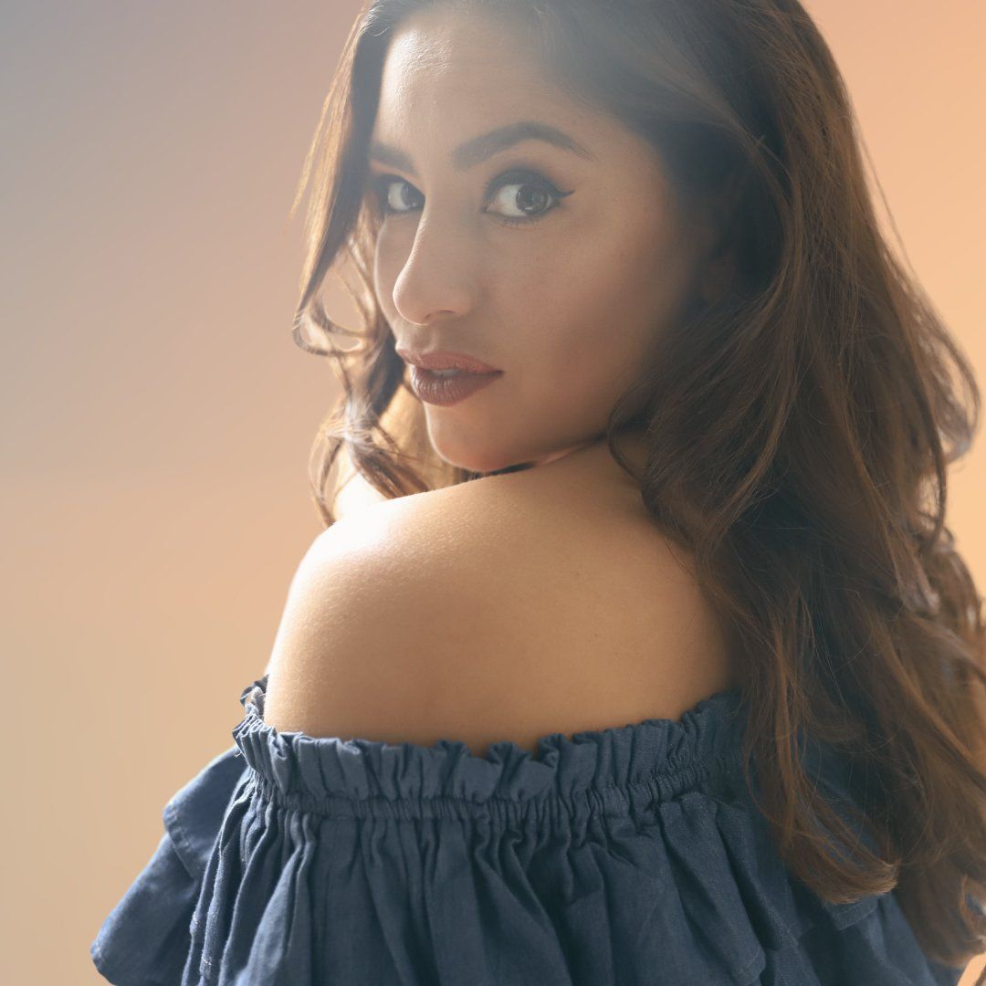 Woman in navy blue off-shoulder top poses against beige wall in multiple angles showing elegant style.