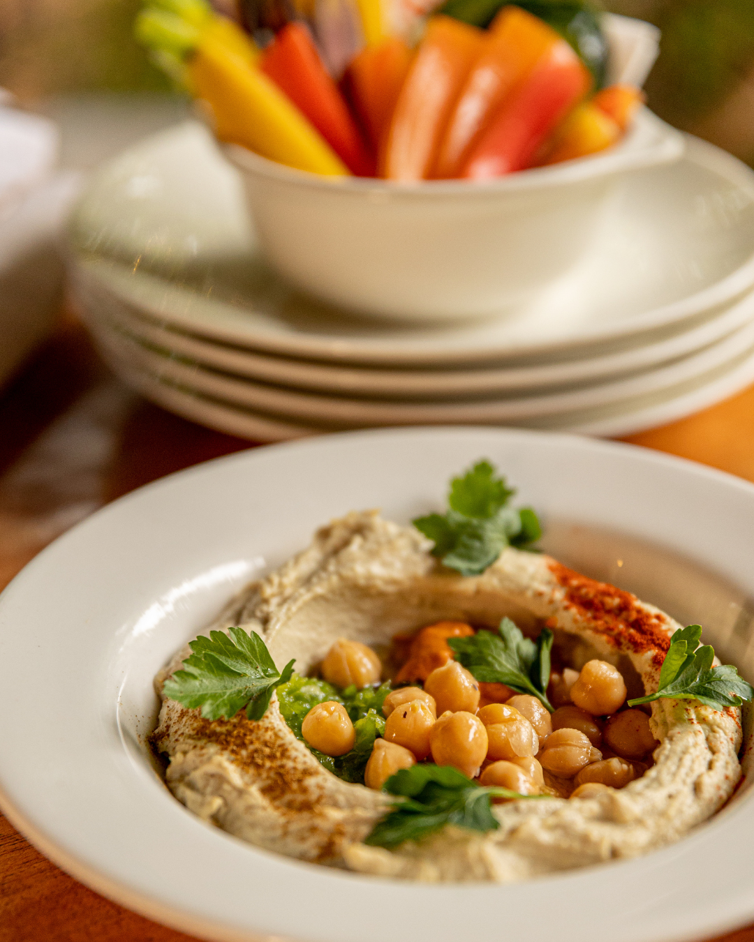 Creamy hummus plates garnished with chickpeas, herbs, and paprika.