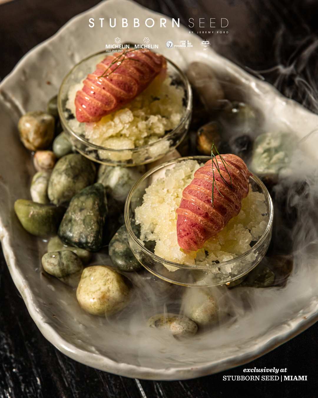 Delicate seafood dish with lobster served on ice with decorative stones.