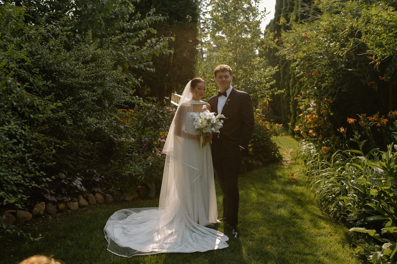Bride and groom pose during golden hour in garden at Wisconsin garden wedding