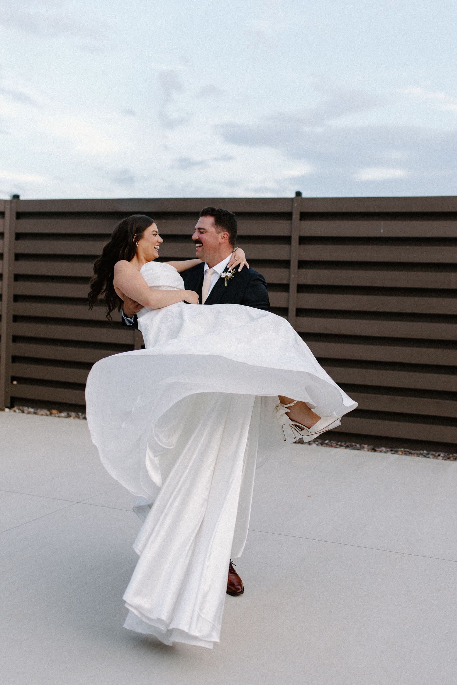 Couple in wedding attire dancing and spinning on a terrace in Oconomowoc, Wisconsin wedding