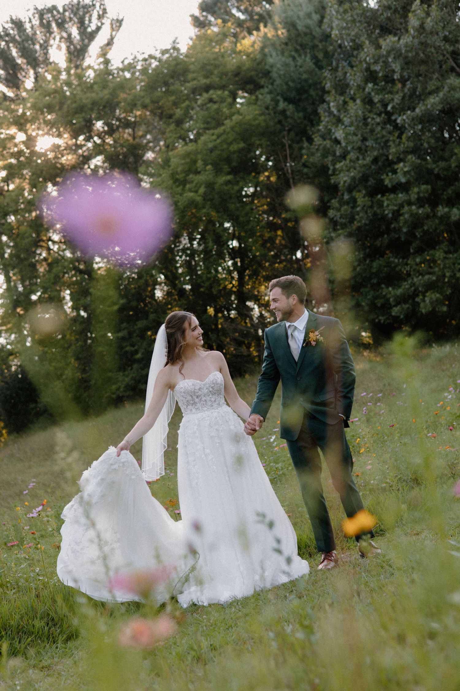 Newlyweds share tender moments in a wildflower meadow during golden hour farm wedding in Wisconsin Dells