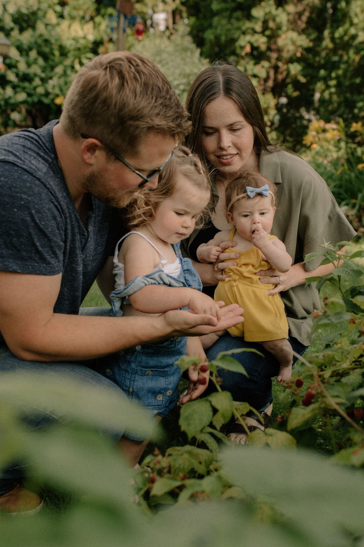 Family gathering among green foliage in a garden setting for family photos