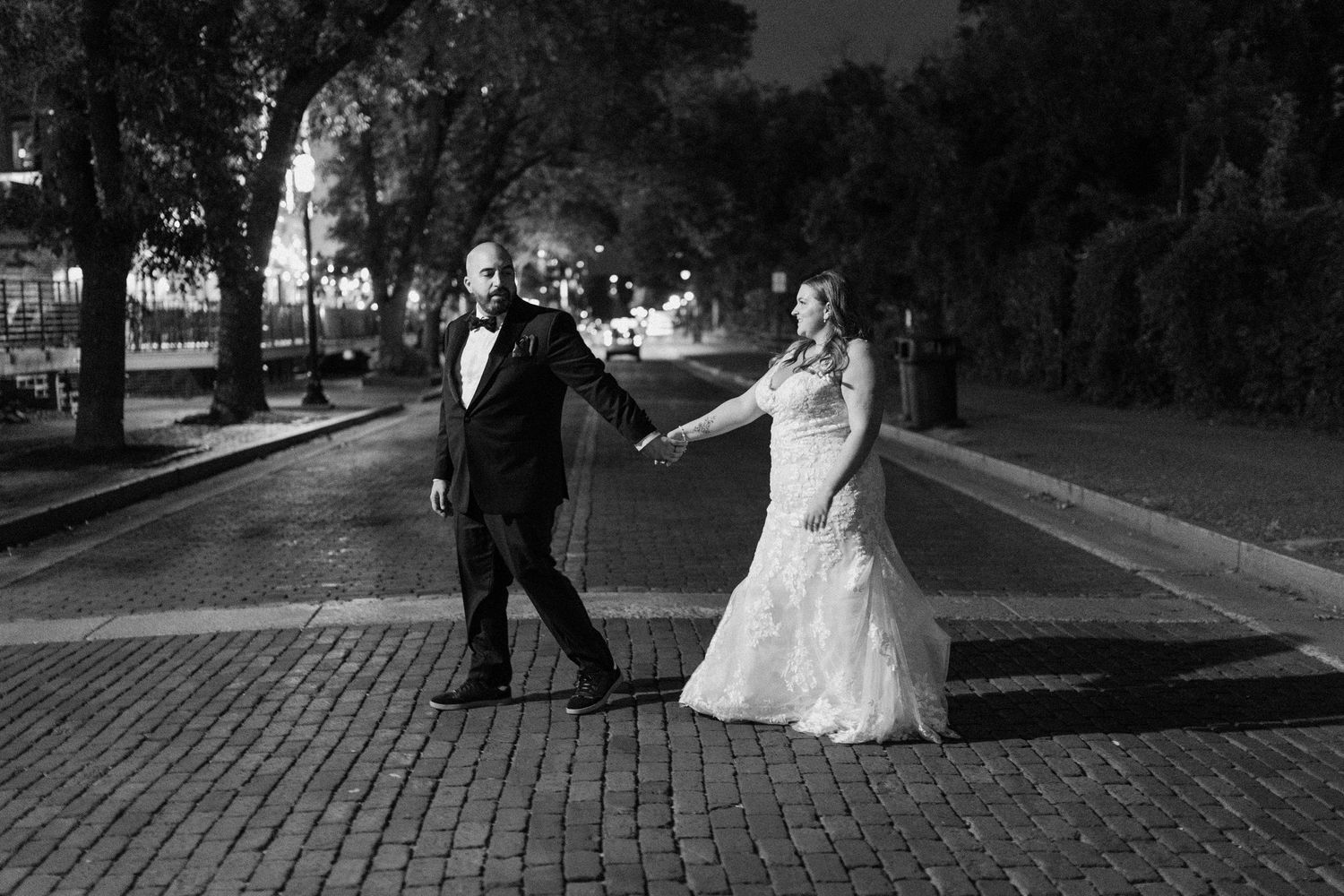 Black and white wedding portraits on Minneapolis cobblestone street with dramatic lighting