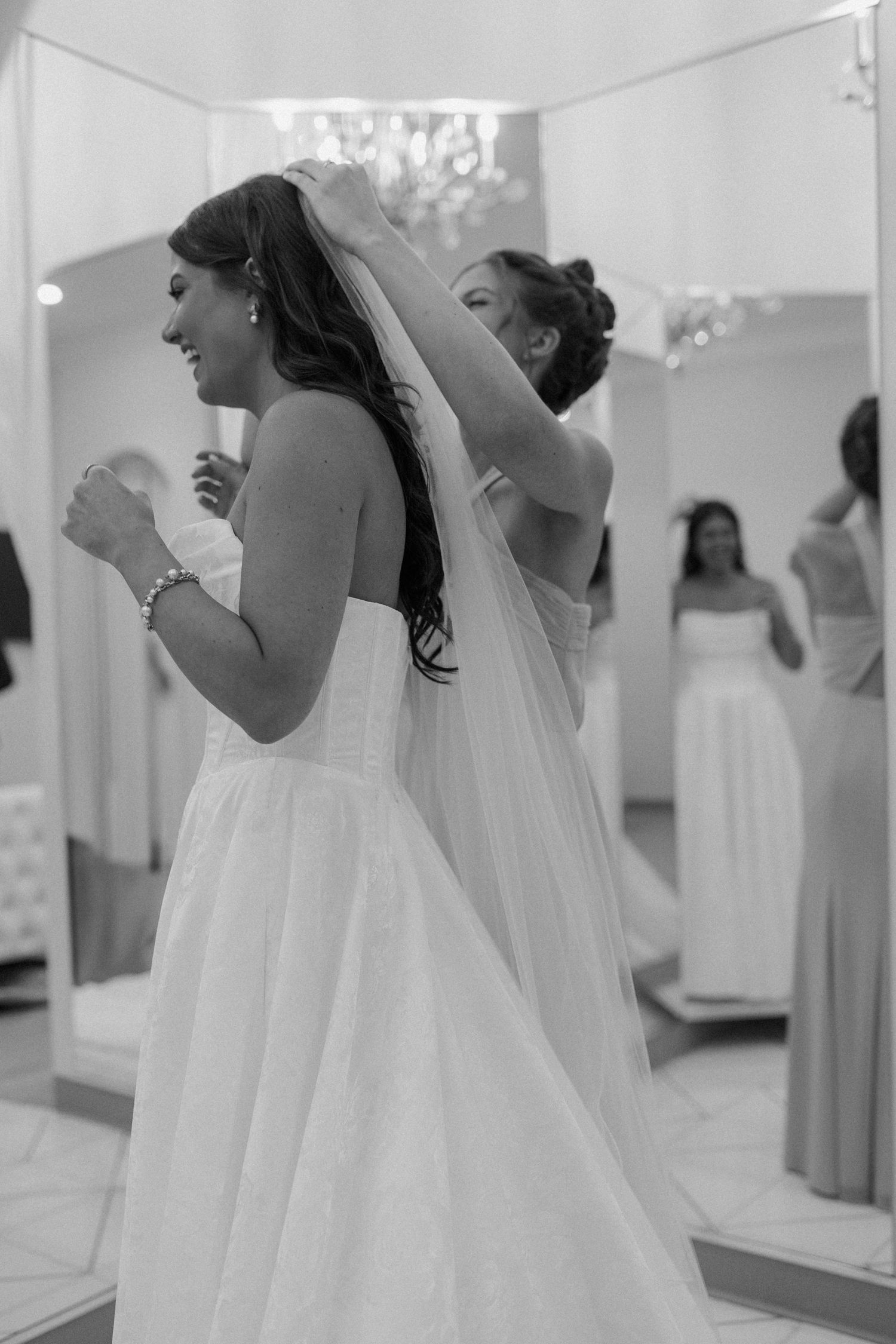 A bride gets help with her veil in mirrored bridal suite at The Valerie wedding venue