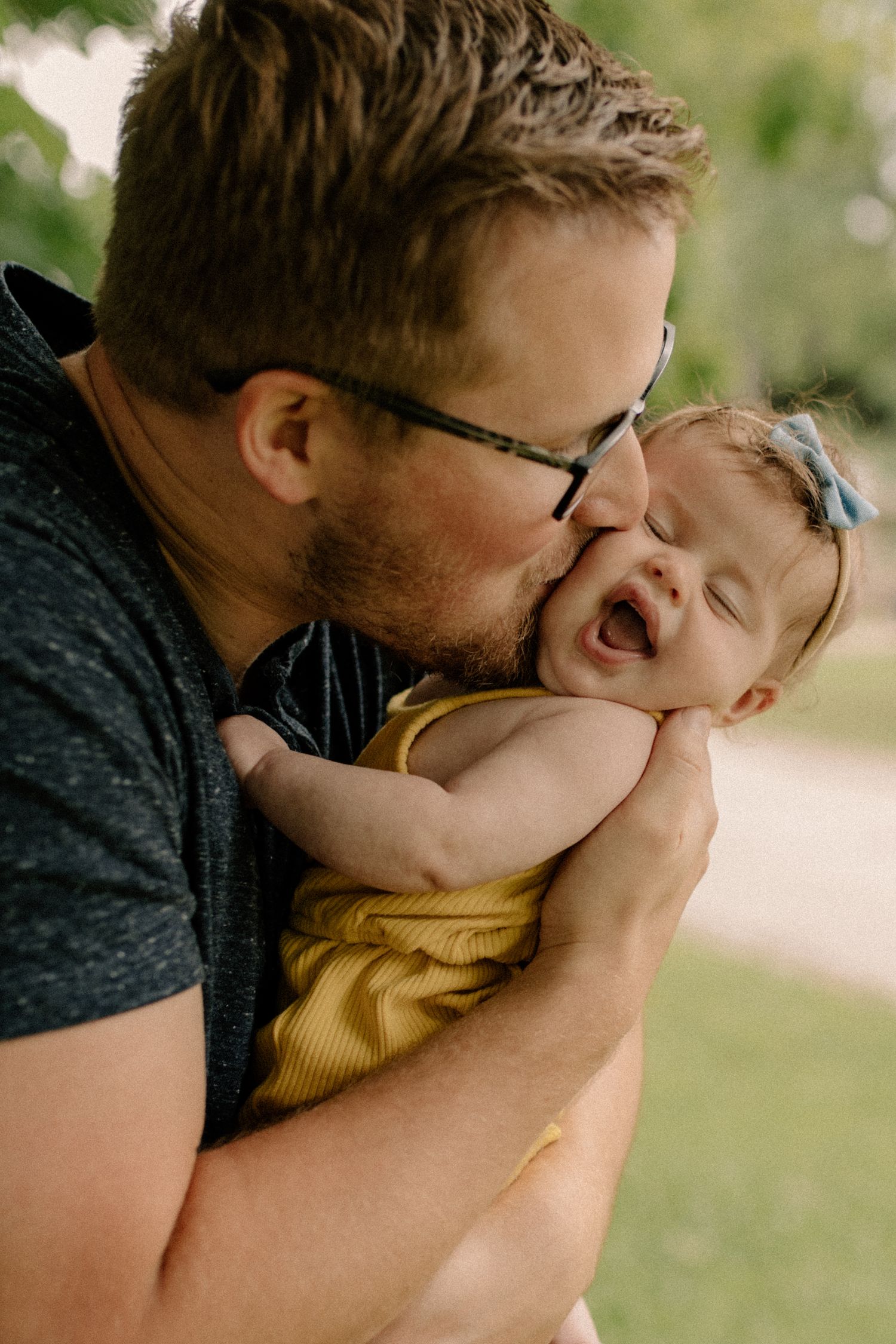 A tender moment captured between parent and baby during an outdoor photo session