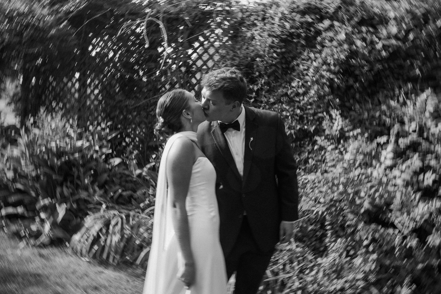 Black and white romantic portrait under garden trellis with soft natural lighting at Wisconsin Gardens Wedding Center