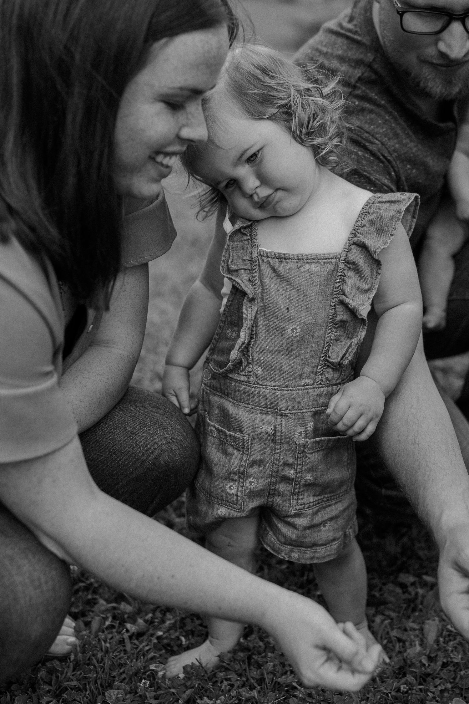 Black and white candid moment shared among family members outdoors for documentary-style family photos
