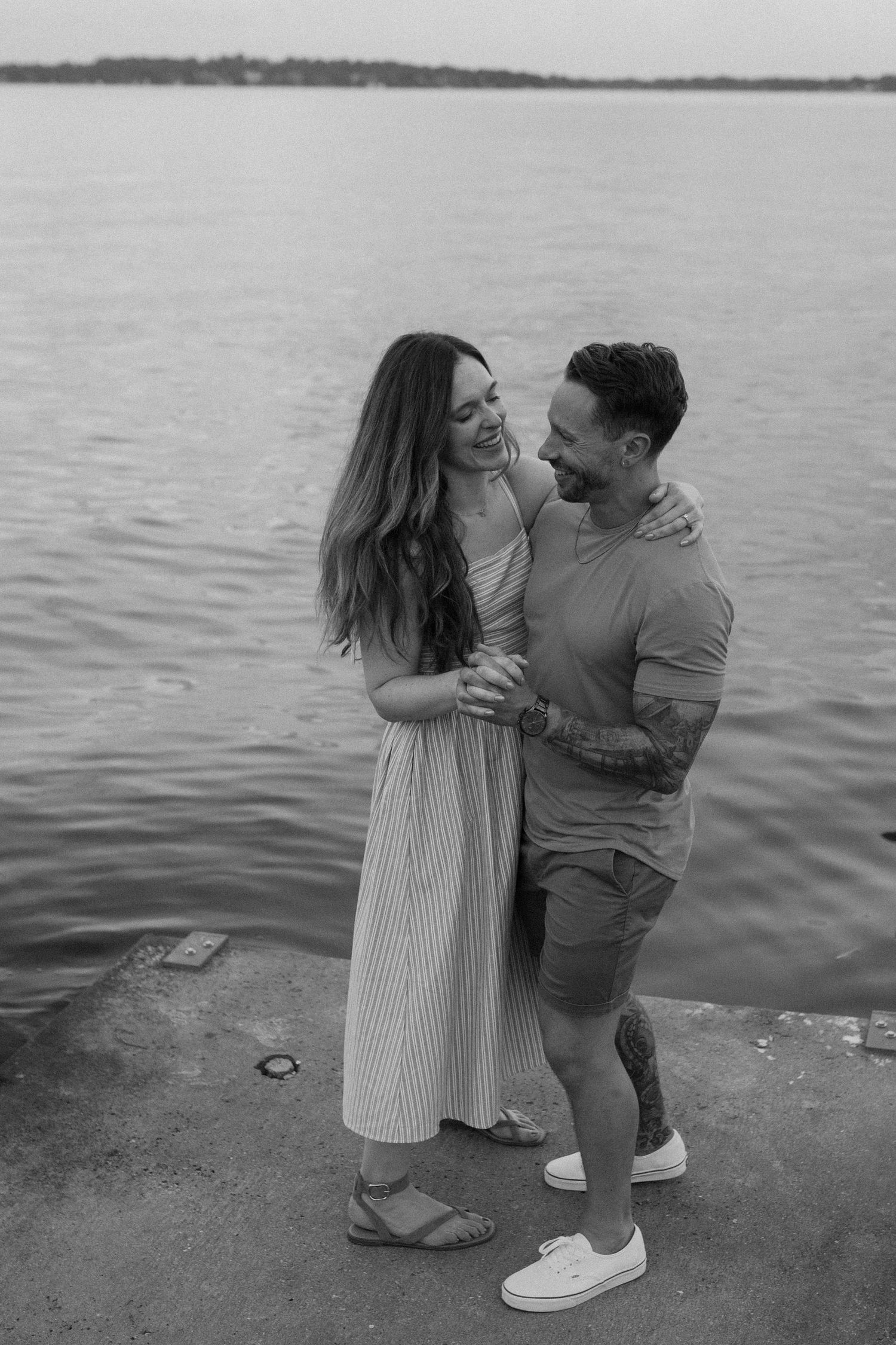 Black and white photo of a couple sharing an intimate moment by the water in Madison, WI couples photography session