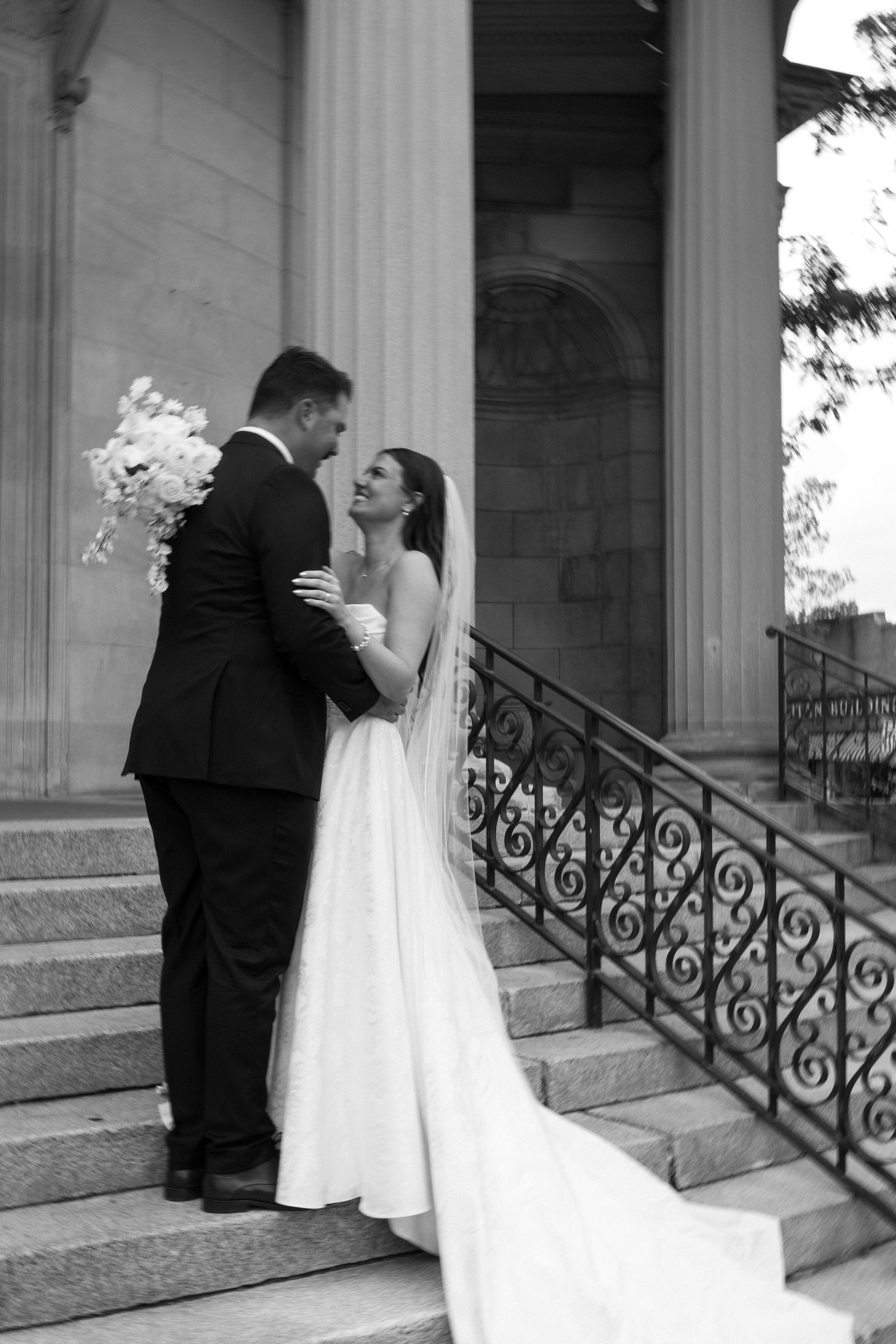A wedding couple shares a tender moment on stone staircase in downtown Waukesha wedding portraits