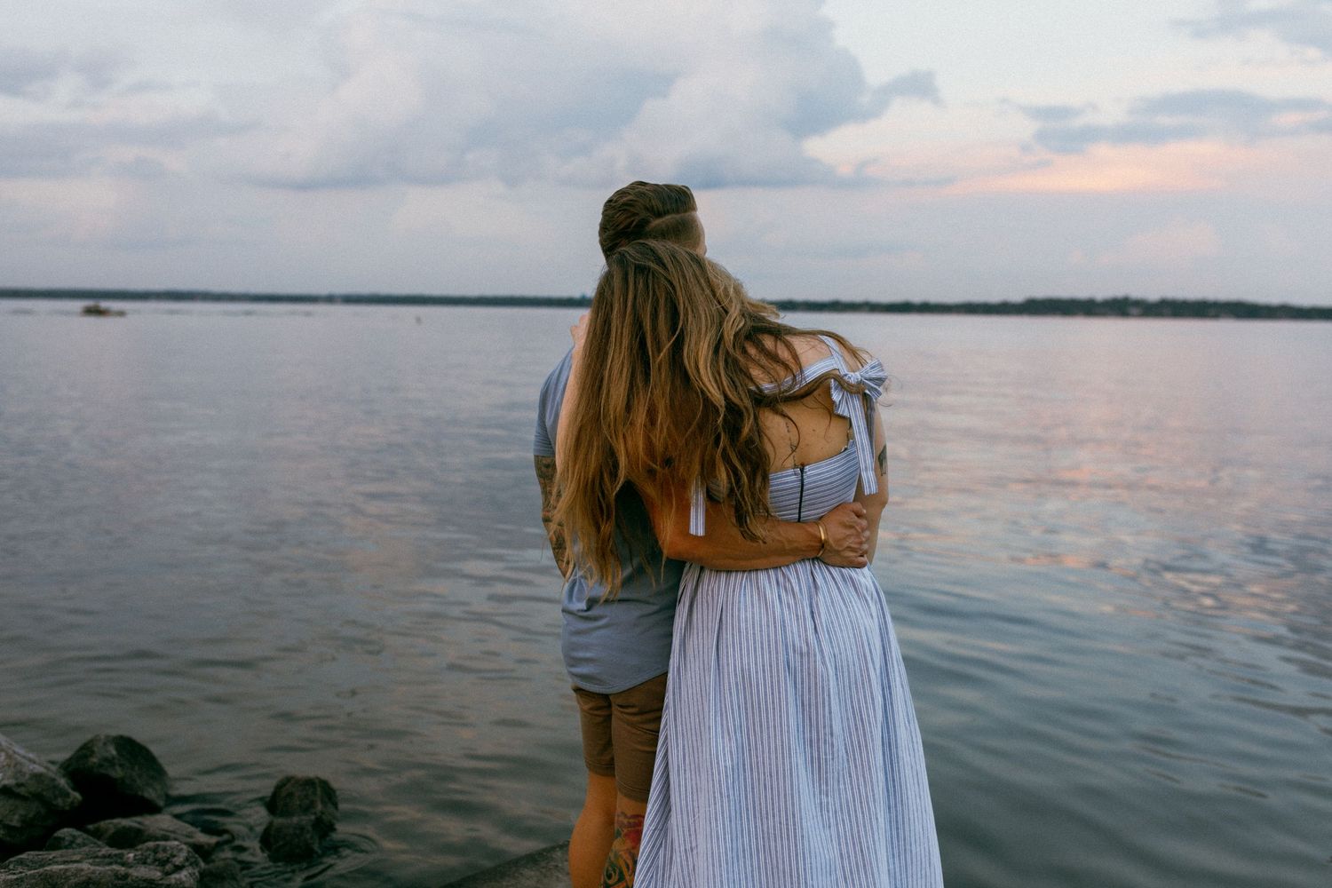 Couple stands together by Lake Mendota in Madison, WI during golden hour couples photography session