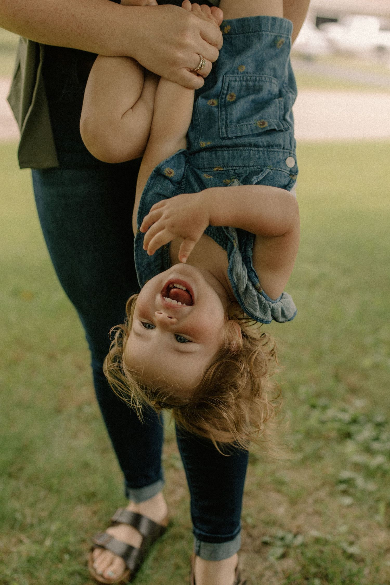 Playful upside-down moments shared between family members in a park setting for outdoor family photos