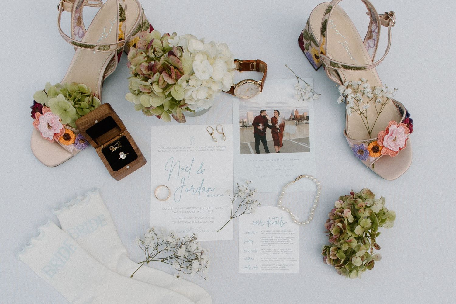 Wedding details and accessories arranged artistically on light background.