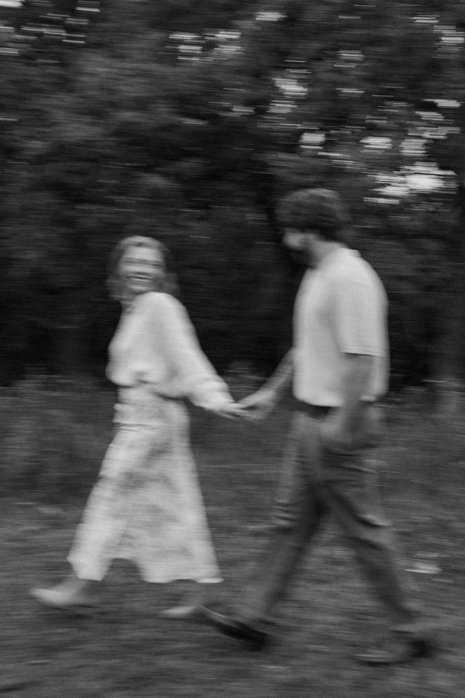 A blurred black and white photo of two people walking through nature at Lapham Peak engagement session photos