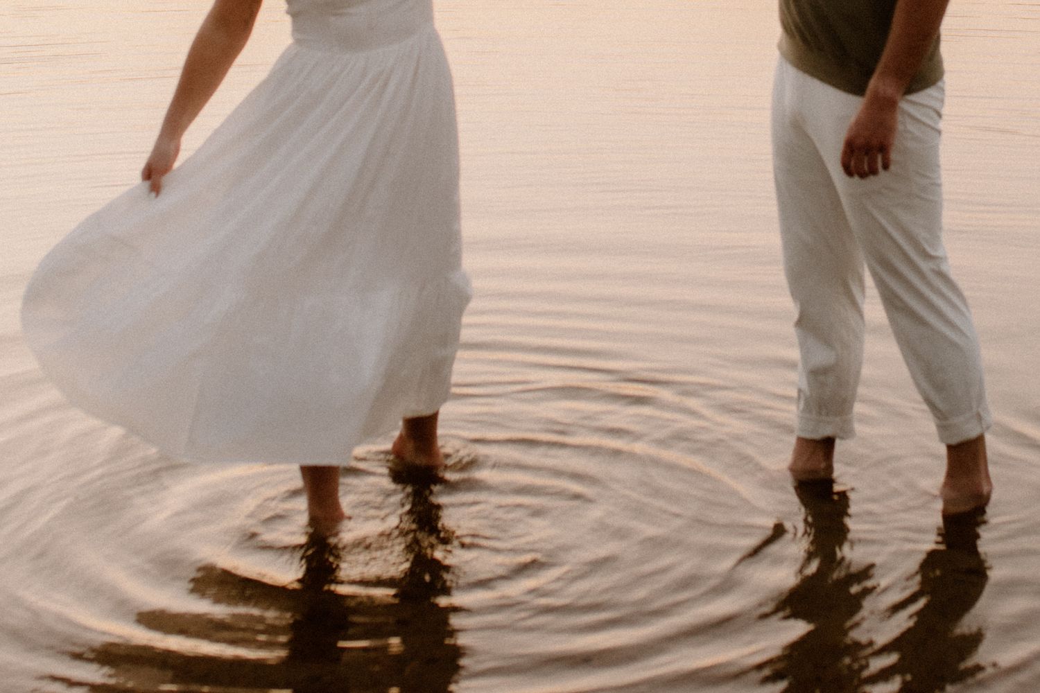 Couple wading in water during golden hour sunset engagement photos