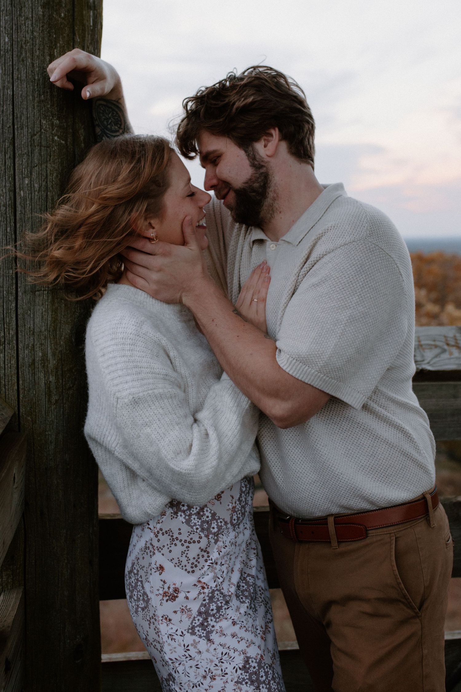 An intimate moment captured between a couple on a wooden observation deck at Lapham Peak engagement session