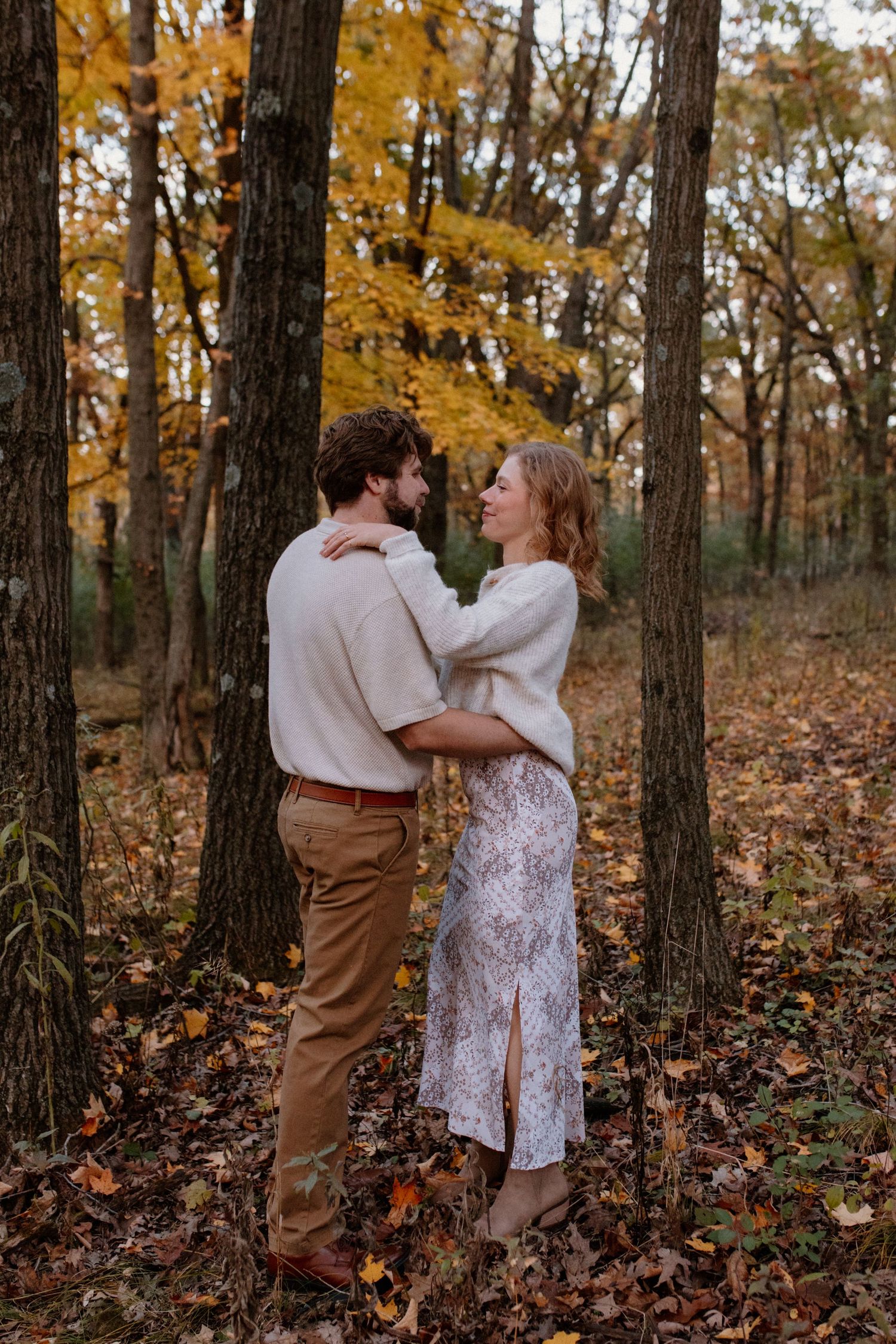 A tender moment between a couple in cozy sweaters amid autumn trees at Lapham Peak engagement session