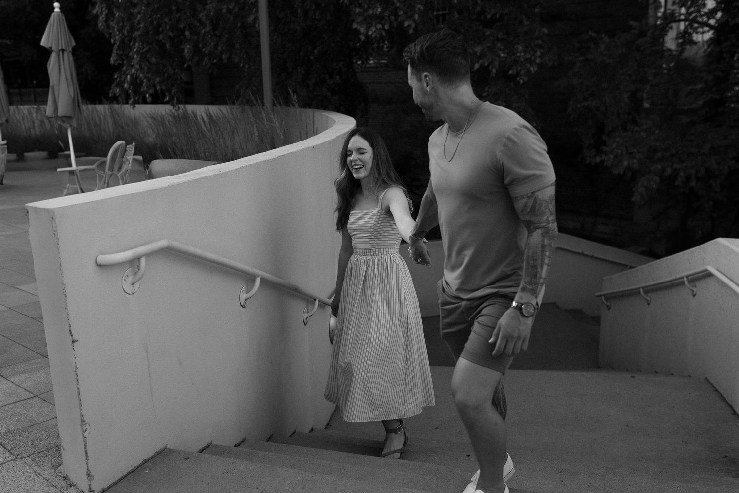 Couple walking down white concrete steps together in a romantic black and white moment in Madison, WI for couples photography session