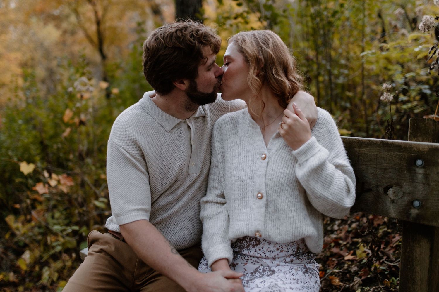 A tender embrace captured against a backdrop of fall colors and trees at Lapham Peak engagement session