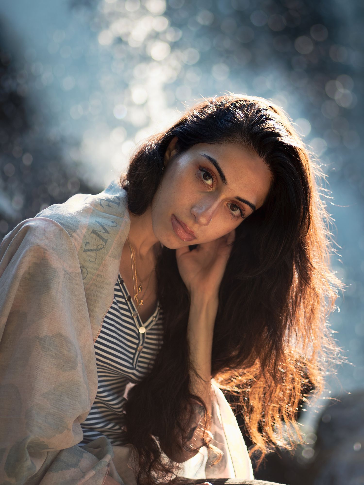 A portrait series shows a person in backlit poses wearing a striped top, creating a dreamy bokeh effect in natural light.