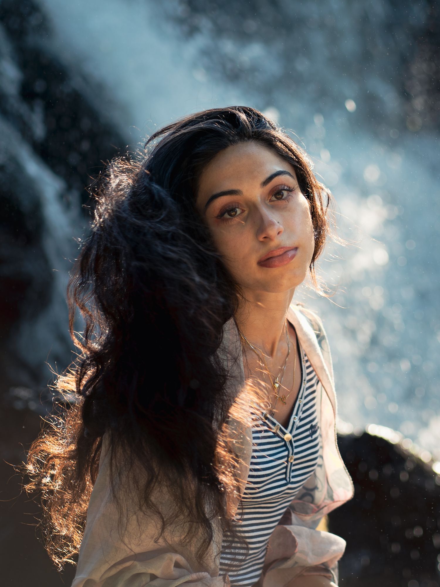 Backlit portrait series showing movement and flowing hair against a soft focus natural background.