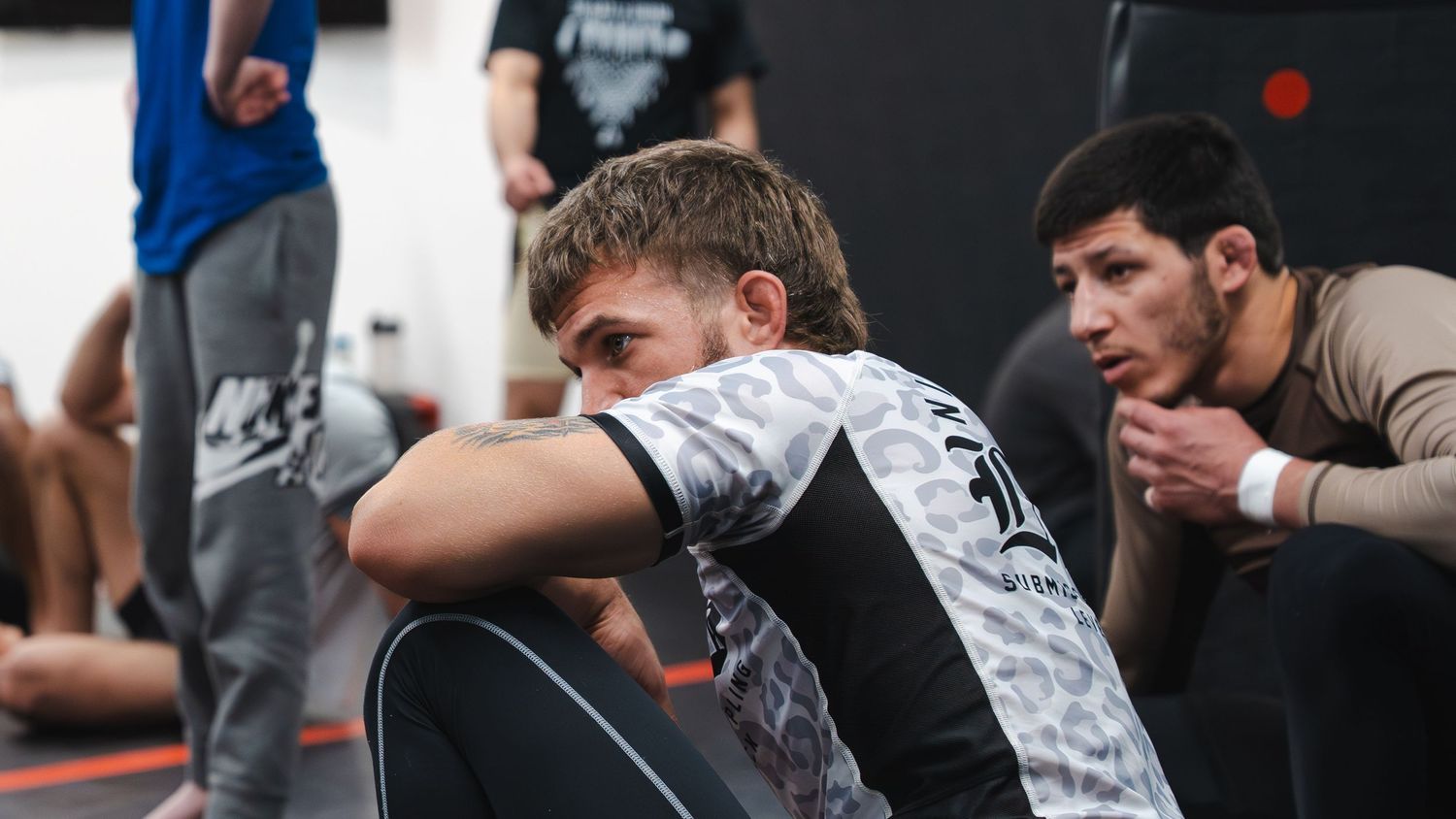 Athletes resting between training sessions at a martial arts facility.